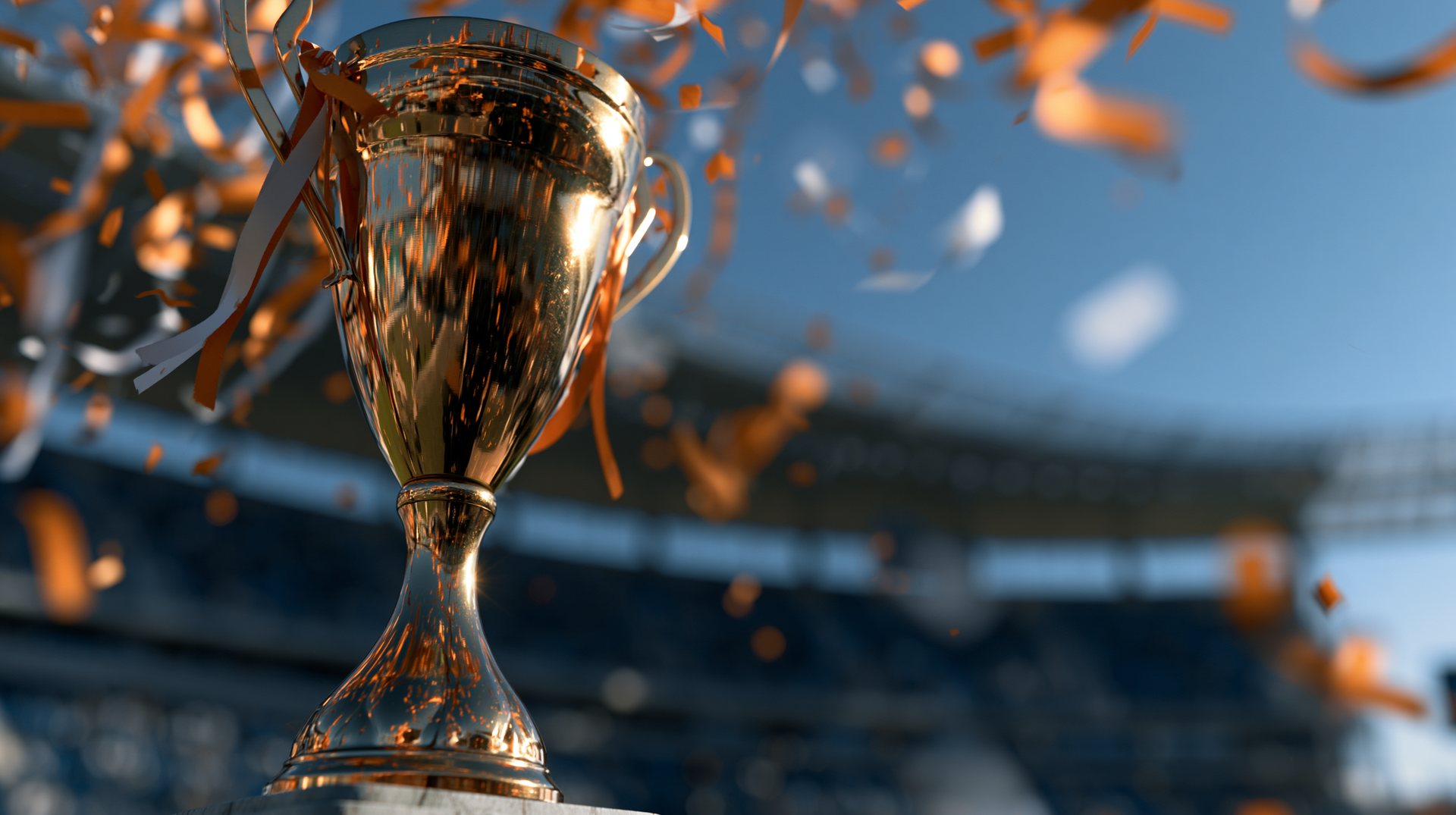 Gouden beker met oranje linten en confetti in het stadion